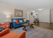 Thumbnail 13 of 25 - a living room with a blue couch and orange chairs