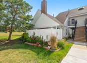 Thumbnail 19 of 24 - the front yard of a house with a white fence and flowers