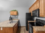Thumbnail 4 of 24 - a kitchen with black appliances and granite counter tops