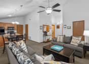 Thumbnail 8 of 24 - a living room and kitchen with a couch and a table