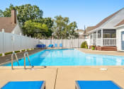 Thumbnail 14 of 24 - a swimming pool in front of a house with a white fence