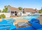Thumbnail 11 of 24 - a swimming pool with blue chairs in front of a house