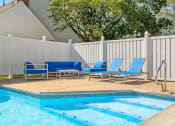 Thumbnail 13 of 24 - a swimming pool with blue lounge chairs next to it