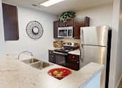 Thumbnail 1 of 27 - A kitchen with a stainless steel refrigerator, microwave, and oven.