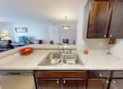 Thumbnail 2 of 27 - A kitchen with a marble countertop and a double sink.