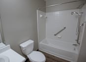 Thumbnail 9 of 37 - A white toilet sits next to a bathtub in a bathroom.