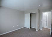 Thumbnail 8 of 37 - A room with a carpeted floor and white walls.