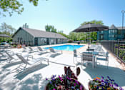 Thumbnail 29 of 37 - A pool area with sun loungers and a black umbrella.