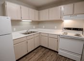 Thumbnail 2 of 37 - A kitchen with white appliances and wooden cabinets.
