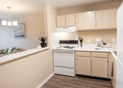 Thumbnail 6 of 26 - A kitchen with a white dishwasher and a white stove top oven.