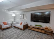 Thumbnail 20 of 37 - A living room with a grey carpet and a television on the wall.