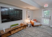 Thumbnail 21 of 37 - A living room with a flat screen TV mounted on the wall.