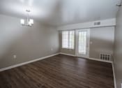 Thumbnail 5 of 37 - A room with a wooden floor and a chandelier.