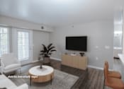 Thumbnail 13 of 37 - A living room with a white chair, a brown chair, a white sofa, a wooden coffee table, a flat screen TV, and a plant.