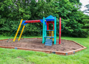 Thumbnail 14 of 22 - a playground with a colorful swing set in a park