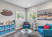Thumbnail 23 of 27 - a clubhouse area with two blue chairs and a table