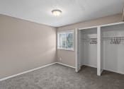 Thumbnail 12 of 27 - an empty bedroom with a closet and a window