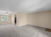 Thumbnail 7 of 27 - an empty living room with carpet and a ceiling fan