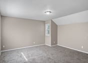Thumbnail 8 of 27 - an empty living room with carpet and a light on the ceiling