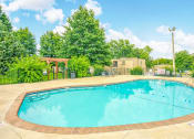 Thumbnail 24 of 27 - a swimming pool with trees and a building in the background