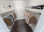 Thumbnail 9 of 28 - A white closet with clothes hanging on hangers.