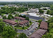 Thumbnail 14 of 14 - A parking lot is in front of a building with a green lawn.