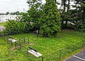 Thumbnail 9 of 18 - A park with a black fence and a bench.