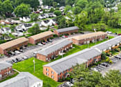 Thumbnail 18 of 18 - A large building complex with a parking lot in front.