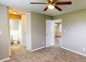 Thumbnail 5 of 18 - A room with a ceiling fan and carpeted floor.