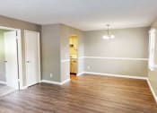 Thumbnail 6 of 18 - A room with wooden floors and a chandelier.