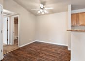Thumbnail 5 of 29 - A room with a ceiling fan and wooden flooring.