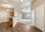 Thumbnail 1 of 29 - A room with a wooden floor and white walls.