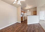 Thumbnail 4 of 29 - A kitchen with white walls and wooden floors.