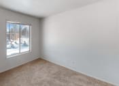 Thumbnail 11 of 19 - a bedroom with a large window and beige carpet