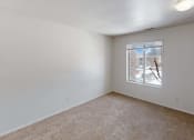 Thumbnail 12 of 19 - a bedroom with a large window and beige carpet