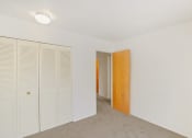 Thumbnail 16 of 19 - a bedroom with white walls and a wooden door