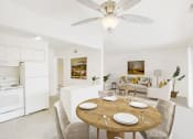 Thumbnail 2 of 19 - a dining area with a wooden table and chairs and a kitchen in the background