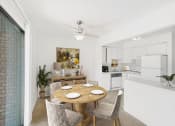 Thumbnail 3 of 19 - a dining area with a table and chairs and a kitchen in the background