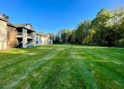 Thumbnail 24 of 24 - Open green area with woods by huntington glen apartments