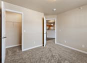 Thumbnail 12 of 29 - A room with a carpeted floor and a doorway leading to another room.
