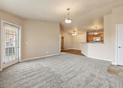 Thumbnail 6 of 29 - A spacious living room with a grey carpet and a white door.