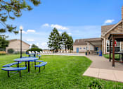 Thumbnail 28 of 29 - Picnic tables are blue and green in a grassy area.