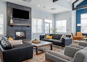 Thumbnail 20 of 38 - A living room with a fireplace and a flat screen TV mounted above it.