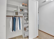 Thumbnail 10 of 22 - a walk in closet with shelves and clothes