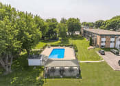 Thumbnail 17 of 22 - an aerial view of a swimming pool in the middle of a yard with a building