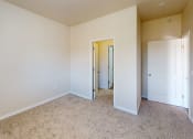 Thumbnail 4 of 16 - a bedroom with white walls and carpeting and a door to a closet