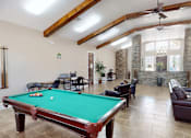 Thumbnail 14 of 30 - A pool table is in the middle of a room with a couch and chairs.