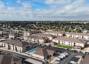 Thumbnail 29 of 30 - A large apartment complex with a swimming pool and a parking lot.