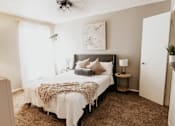 Thumbnail 6 of 25 - A bedroom with a bed, nightstands, and a painting on the wall.