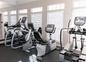 Thumbnail 16 of 25 - A row of treadmills and elliptical machines in a gym.